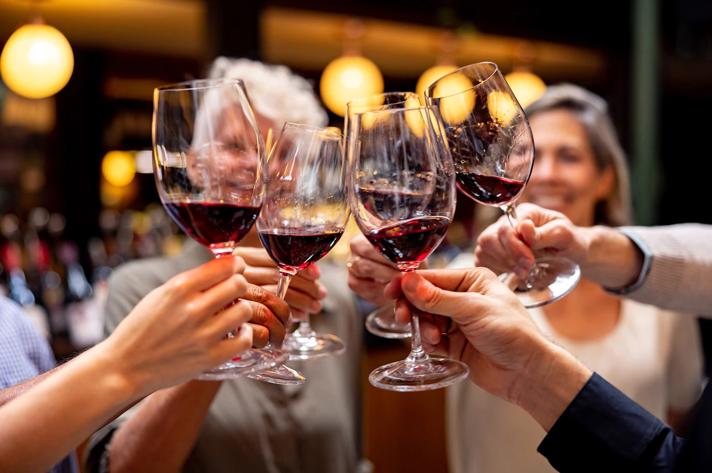 a group of people clinking wine glasses