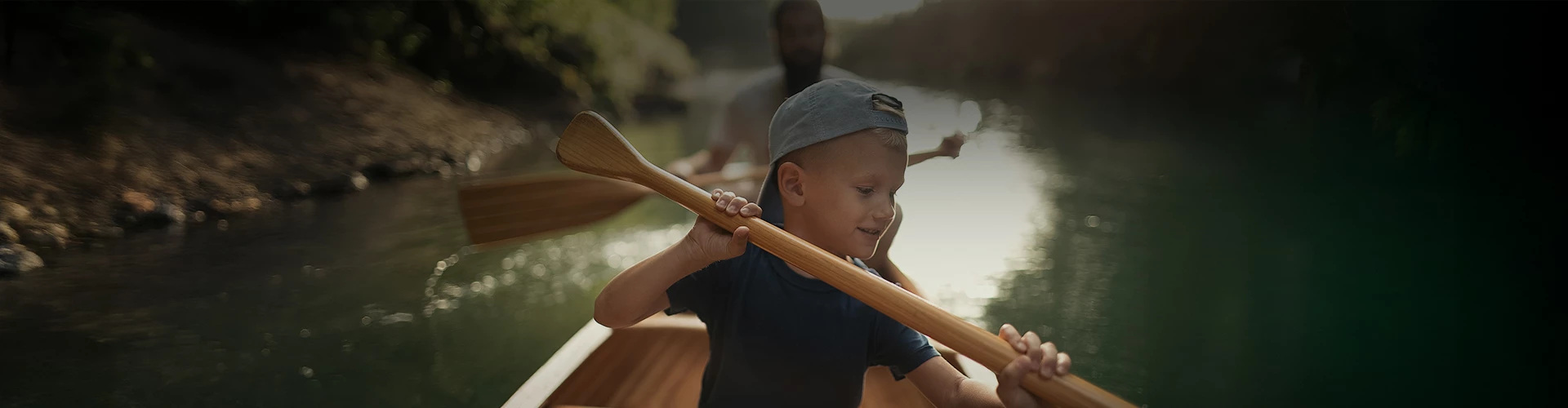 a boy holding a paddle in a boat