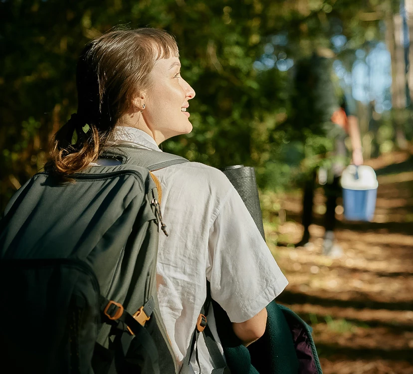 a woman with a backpack in the woods