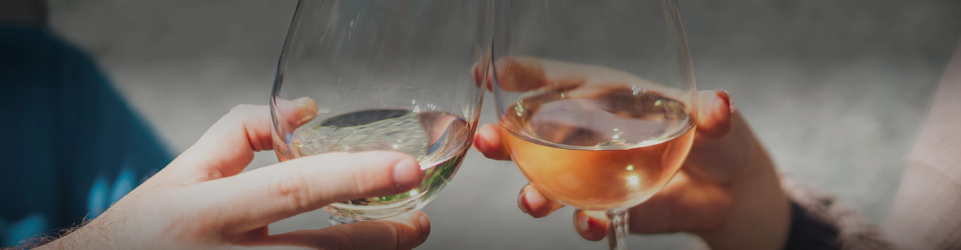 a pair of hands holding wine glasses