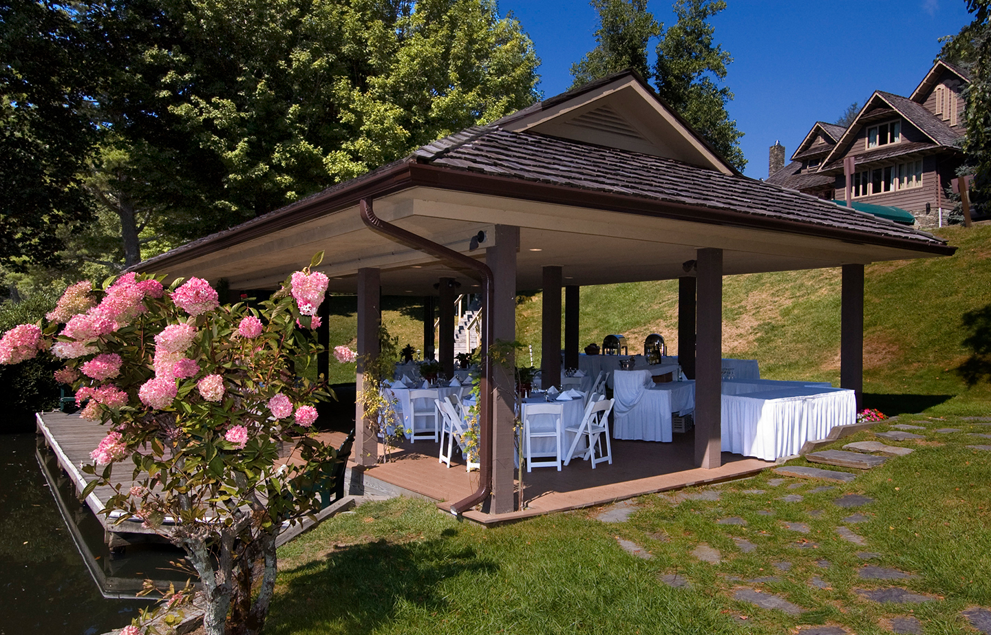 a gazebo with tables and chairs in a grassy area