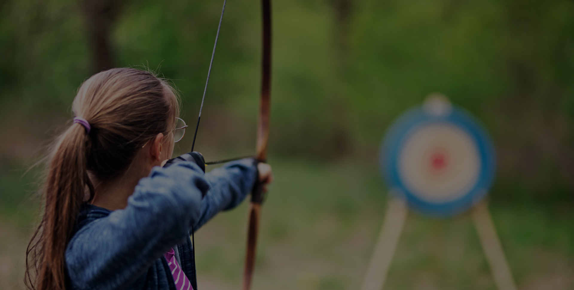 a woman aiming a bow and arrow