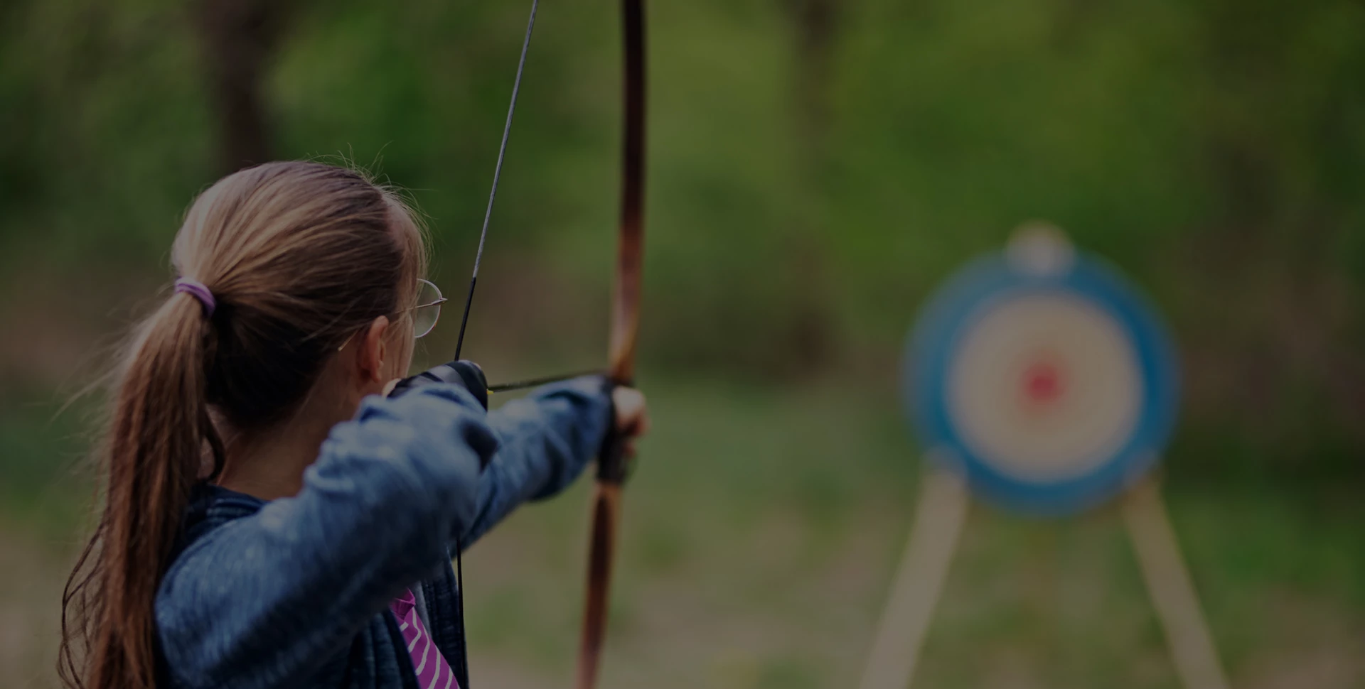 a woman aiming a bow and arrow