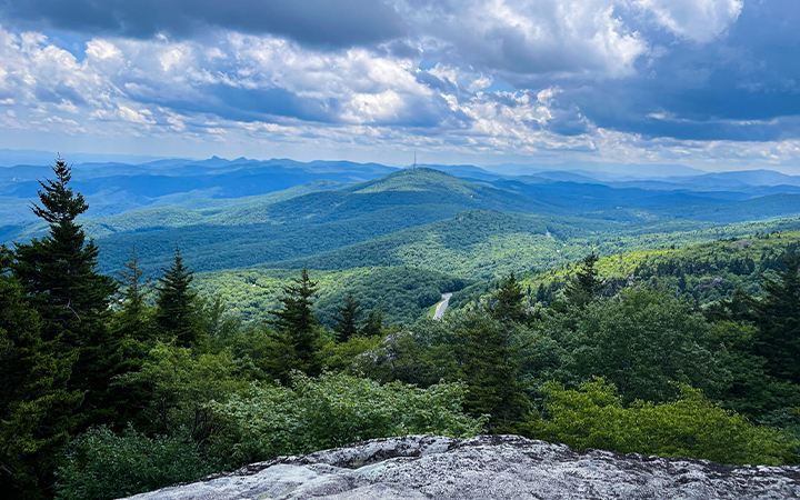 a view of a mountain range from a cliff