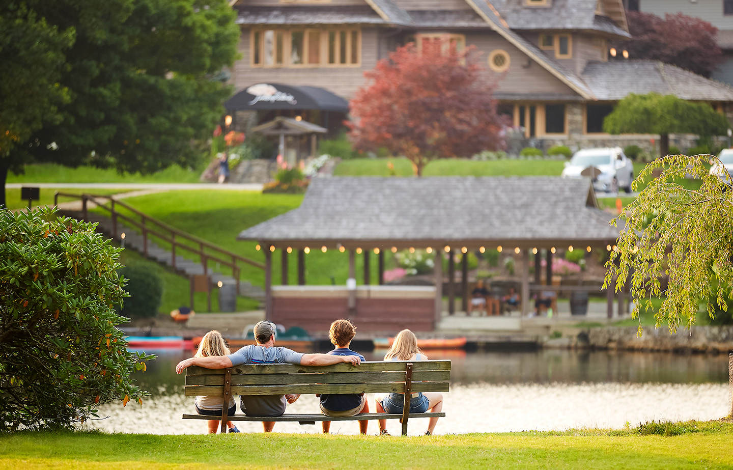 a group of people sitting on a bench by a lake