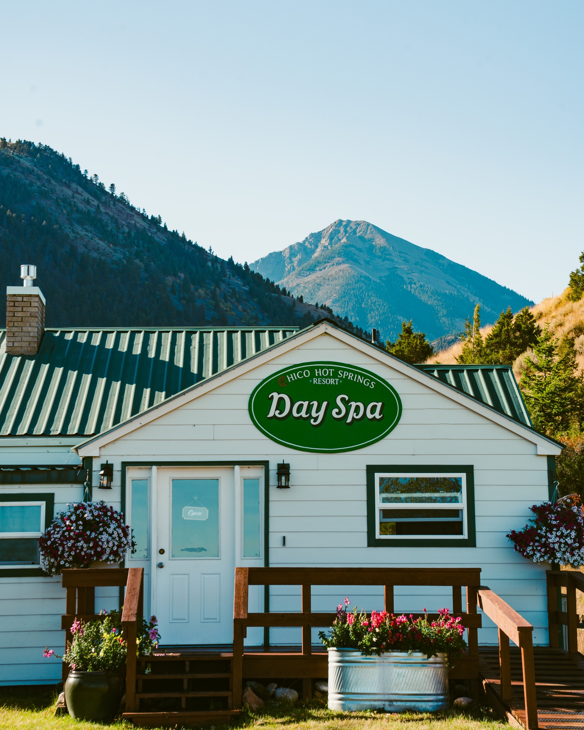 a white building with a green roof and a sign on it.
