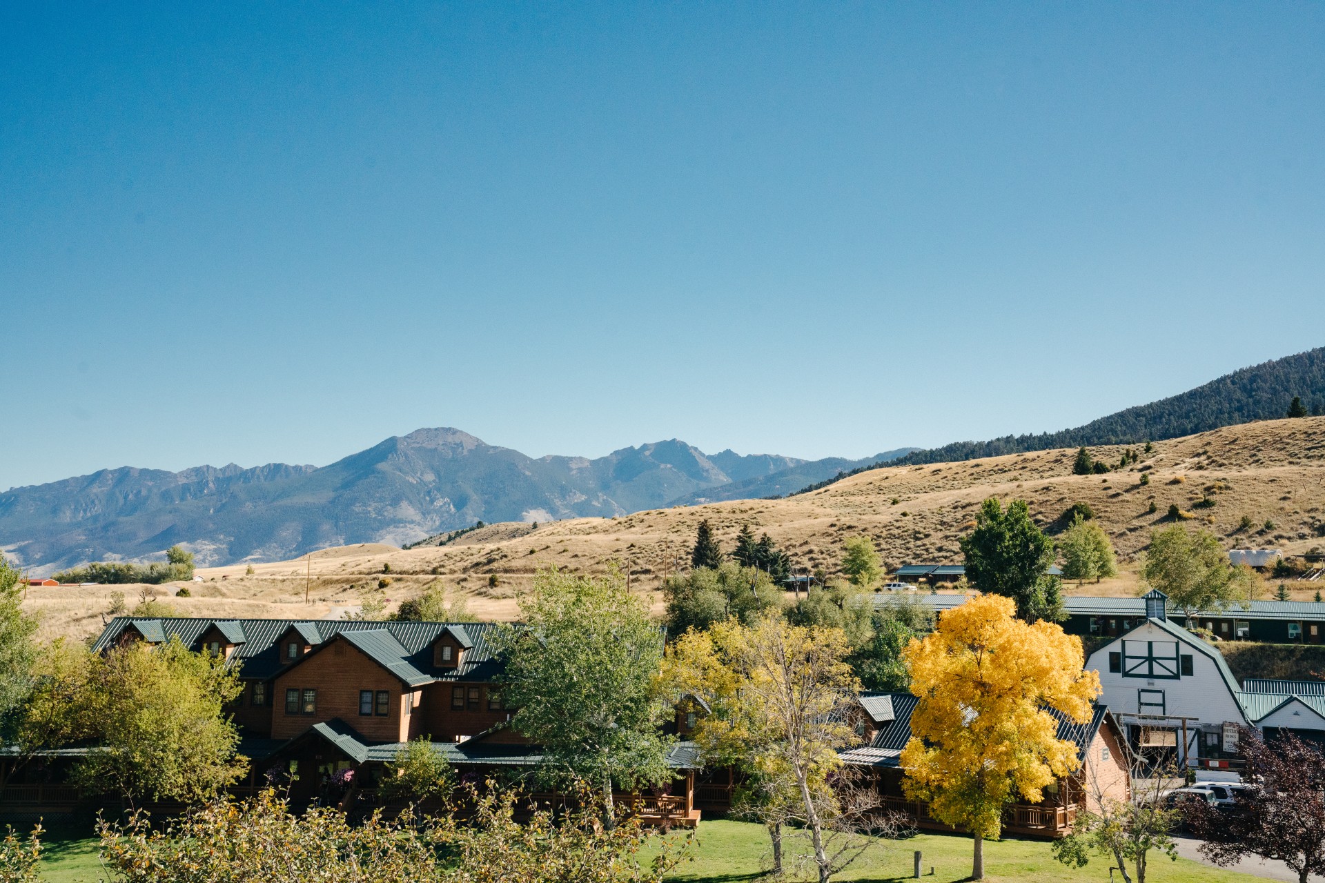 a group of buildings with trees and mountains in the background
