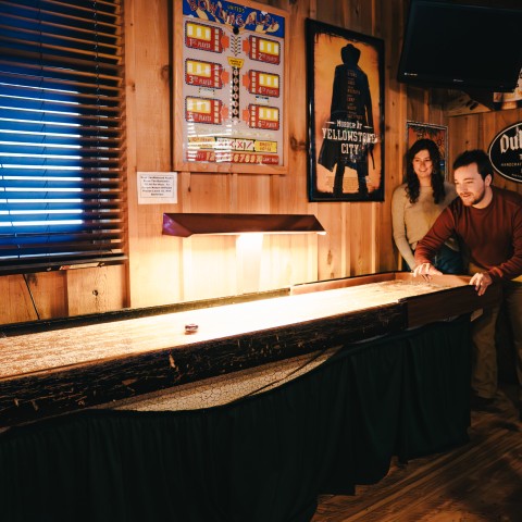 a man and woman playing shuffle board