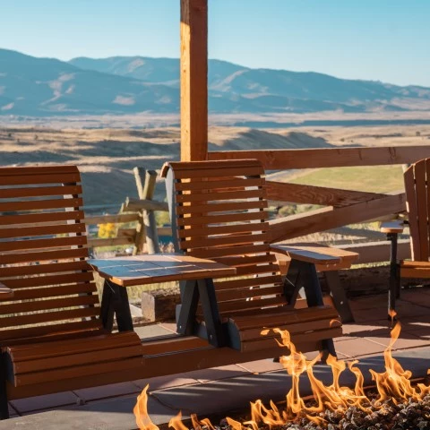 a fire pit with chairs and mountains in the background