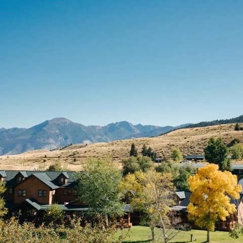 an inn with trees and mountains in the background