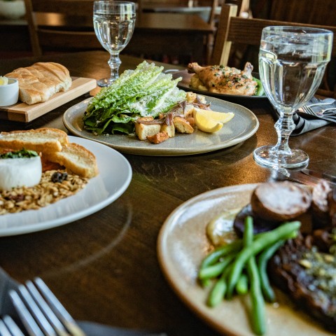 a table with plates of food and glasses of water.
