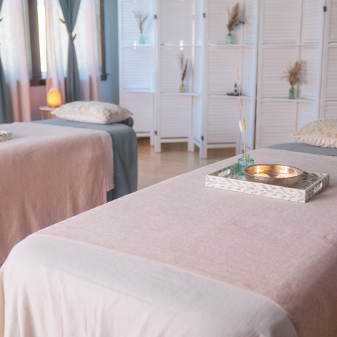 Two massage tables with pillows and a tray on top.
