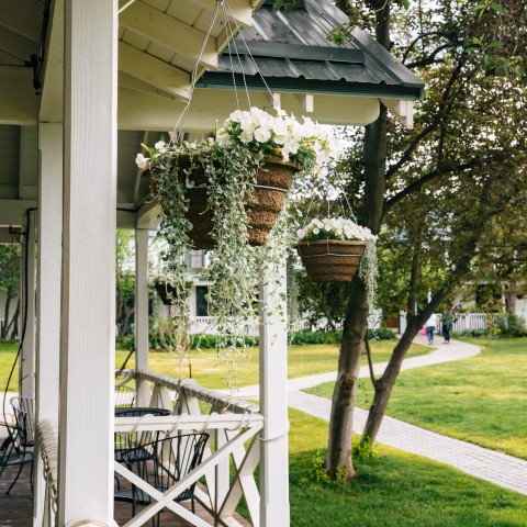 baskets of flowers on a porch.