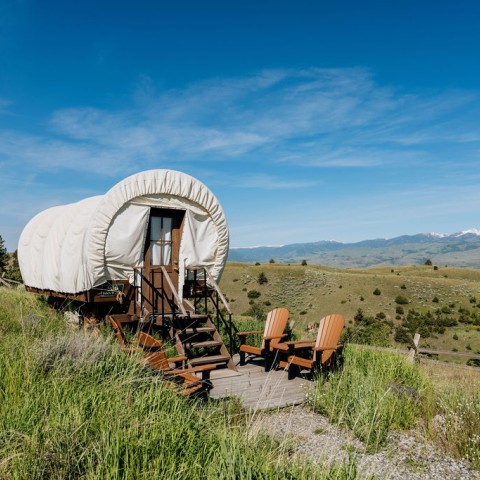 a covered wagon on a hill with Oregon Trail in the background