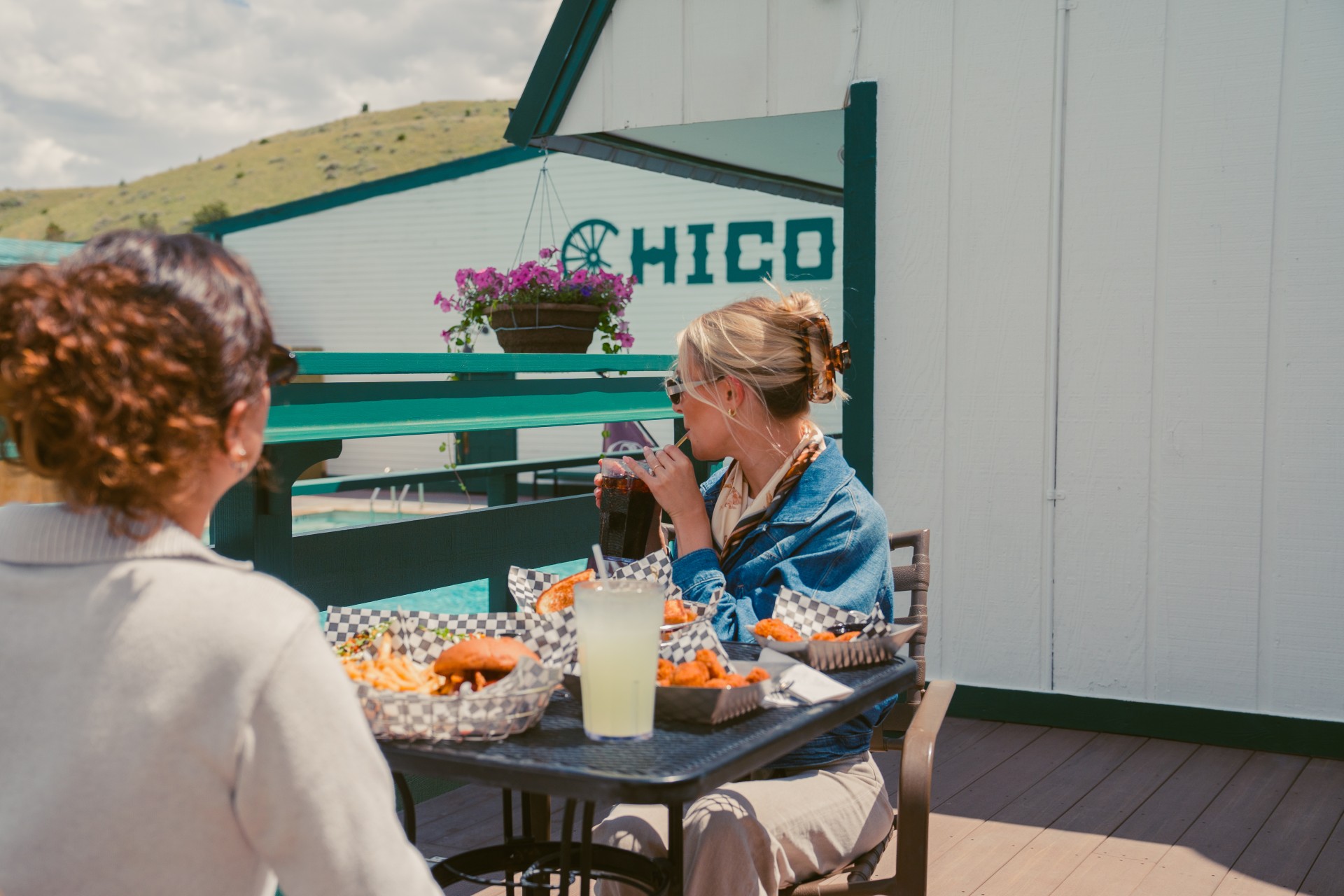 post image for Two women sitting at a table with food and drinks.