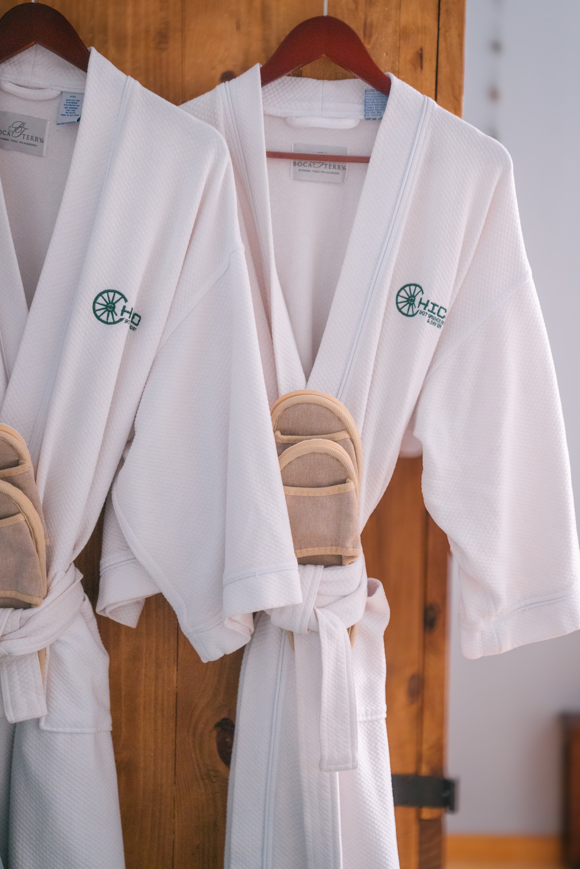 a pair of white bathrobes on a swinger.