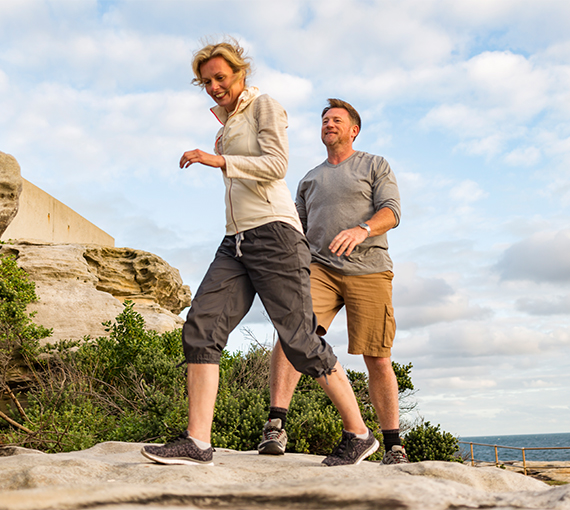 a man and woman walking on a rock