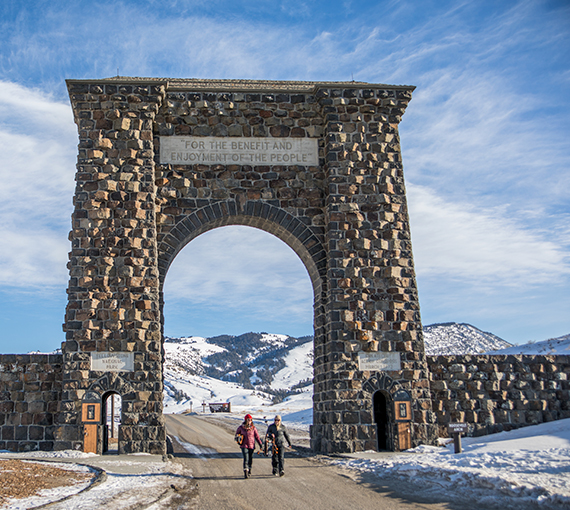 a stone archway with people walking underneath