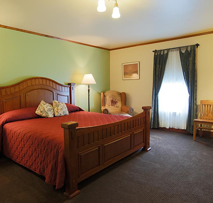a bedroom with a bed and chairs