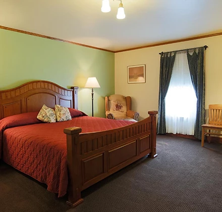 a bedroom with a bed and chairs