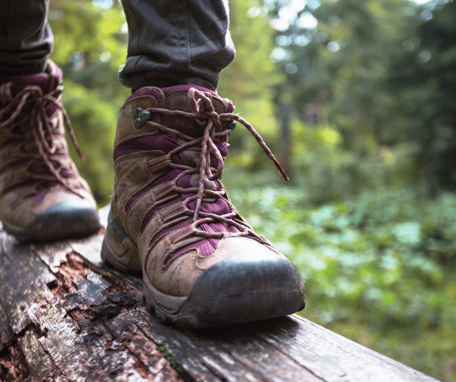 a person's feet in boots on a log