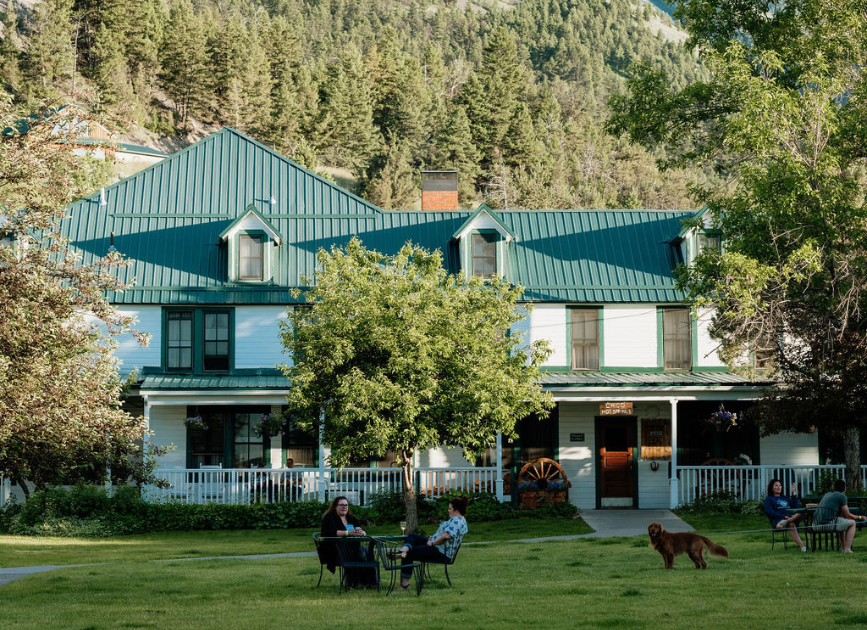 a couple sitting at tables in front of an inn