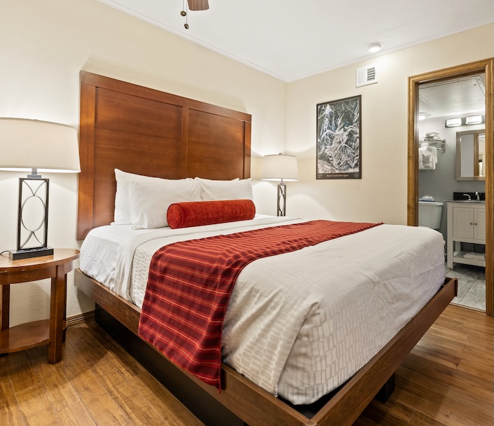 a bed with a wood headboard and a lamp