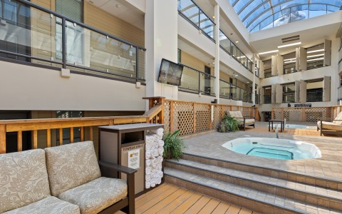 a indoor pool with a hot tub and a glass roof