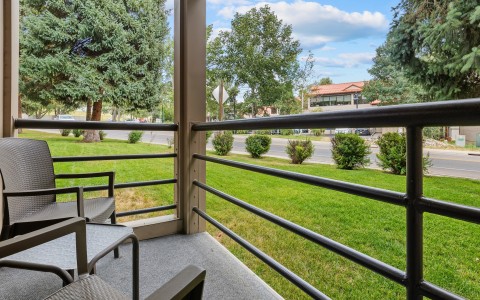 a balcony with a view of grass and trees