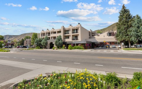 a building with a road and flowers