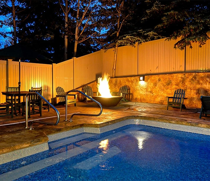 a fire pit with a fire in it by a pool