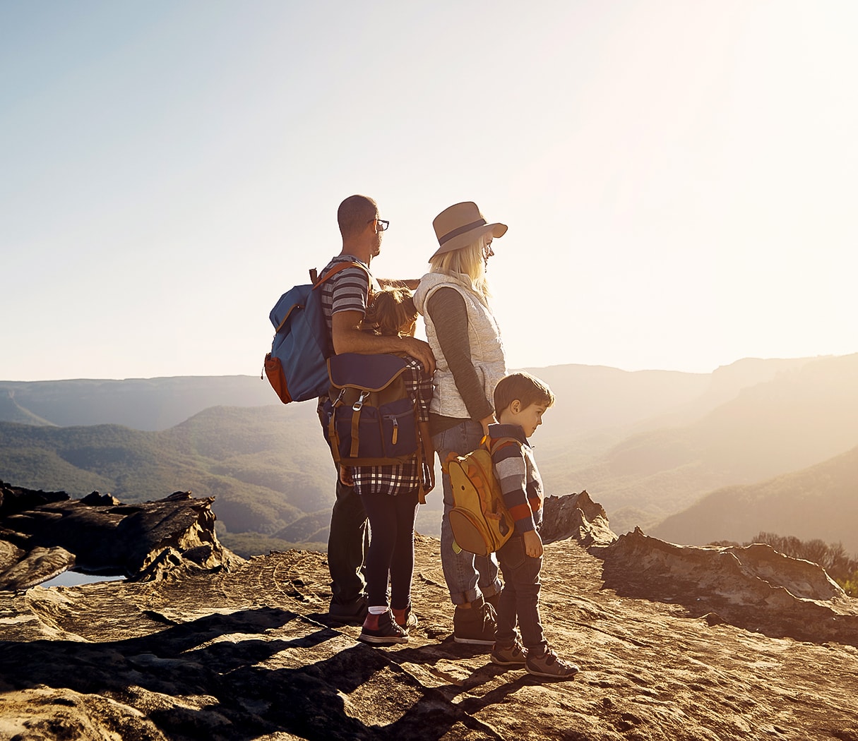 a man and woman with a child on a mountain