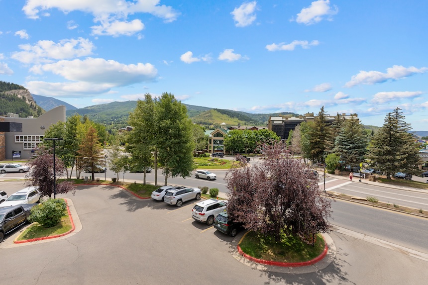 a parking lot with cars and trees in the background