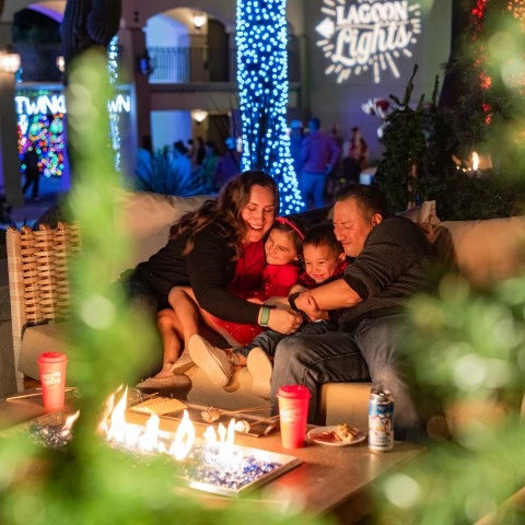 a family sitting on a couch with a fire in the background