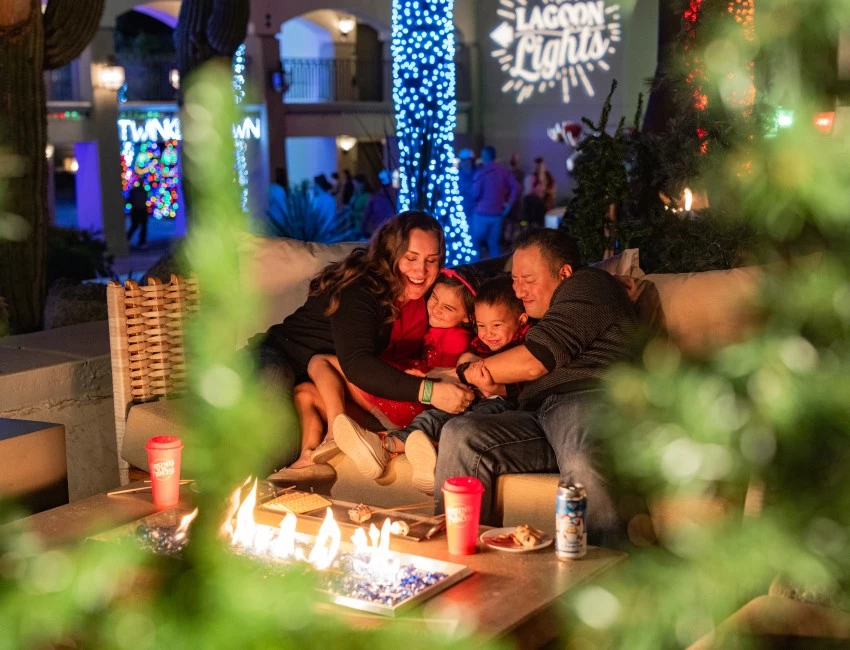 a family sitting on a couch with a fire in the background