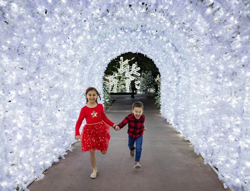 two children running in a tunnel of lights