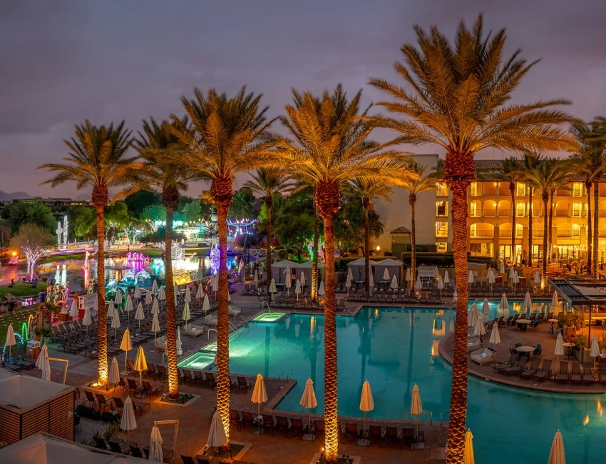 a pool with palm trees and umbrellas