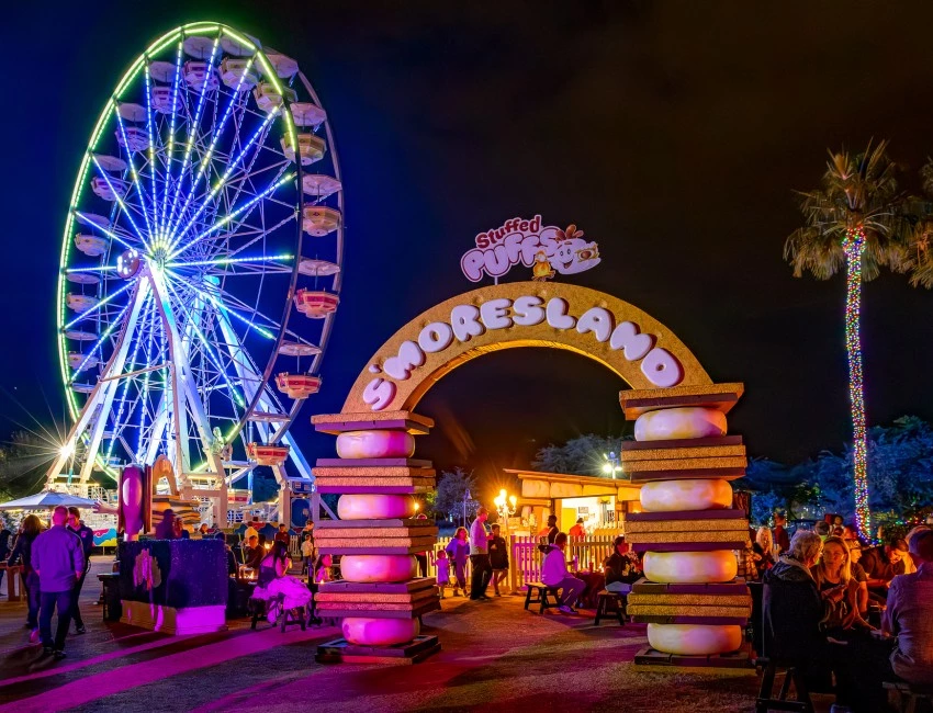 a ferris wheel and a sign at night