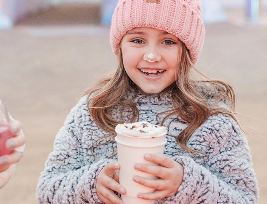 a young girl with whipped cream on her nose