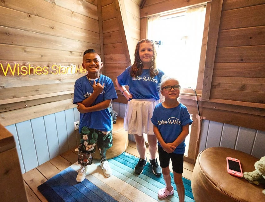 three young kids standing in a room