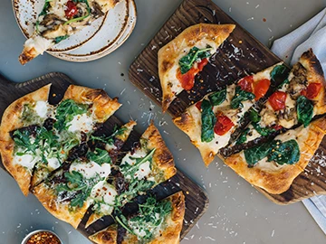 two flatbread on top of wooden boards