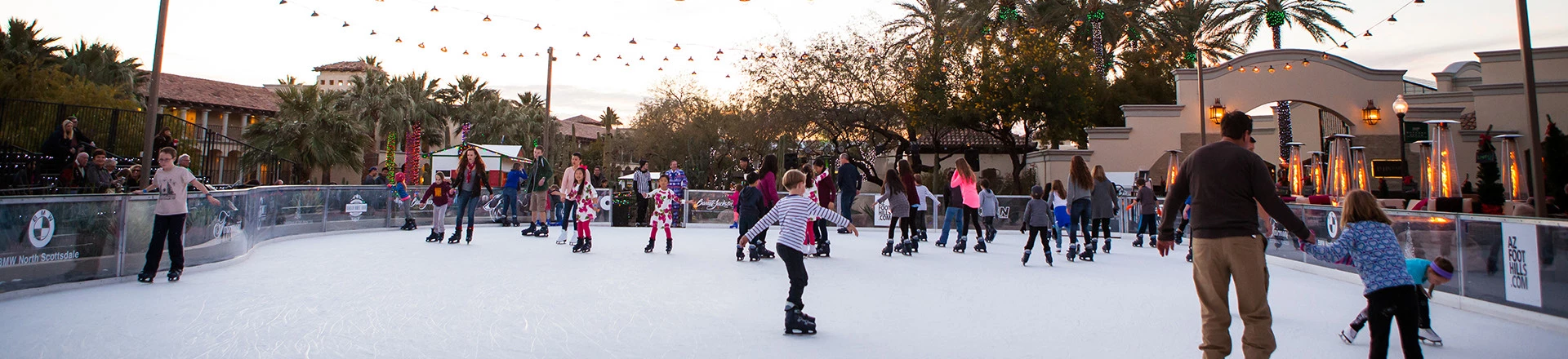 a large group of people ice skating outside during the day
