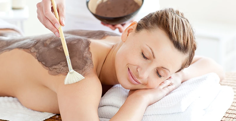 a woman at the spa getting a mask on her back