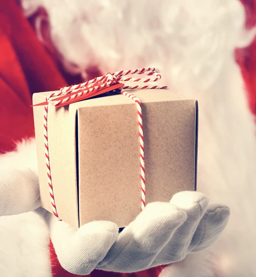 close up of santa holding a small gift