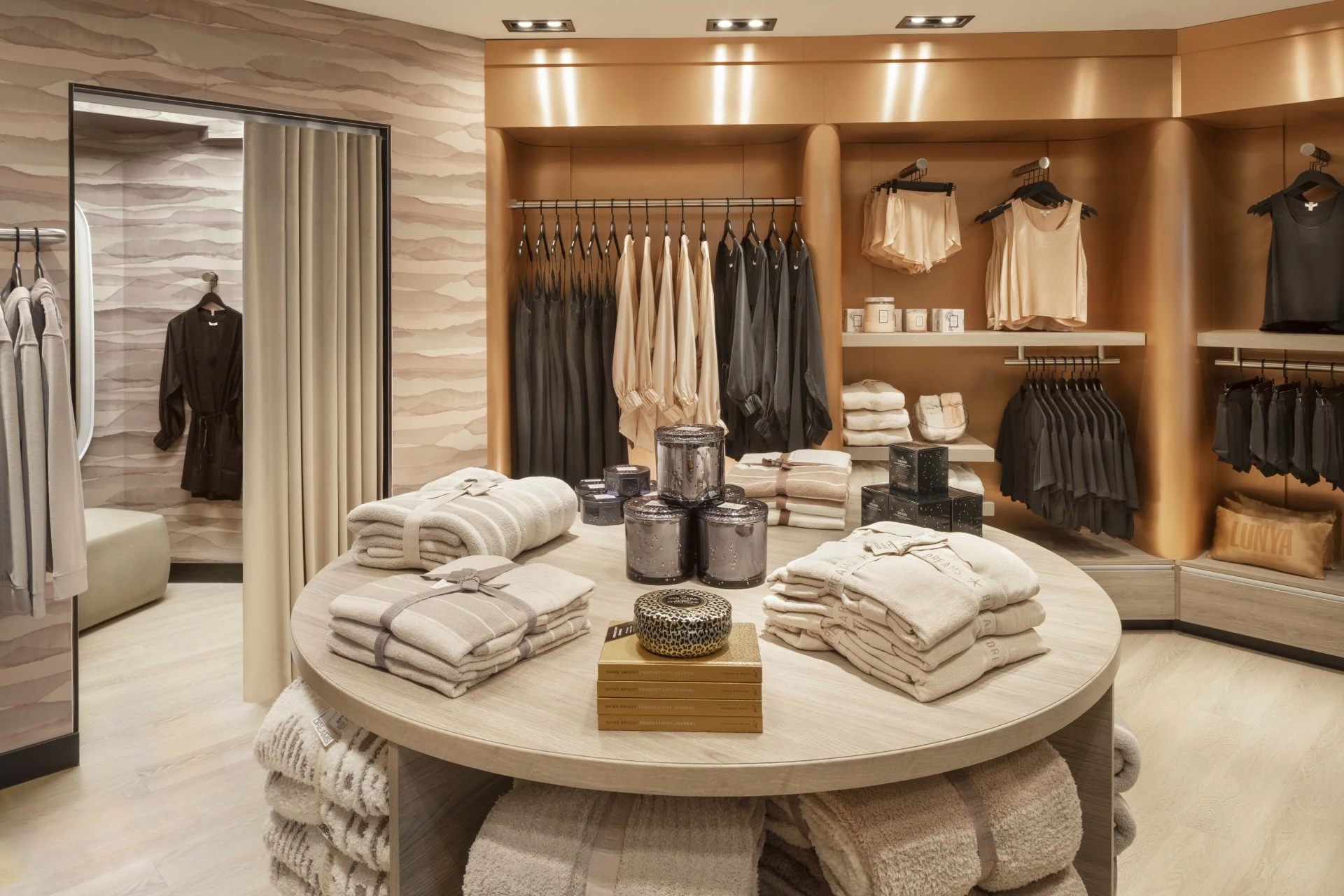 a store with a circular table with towels and candles