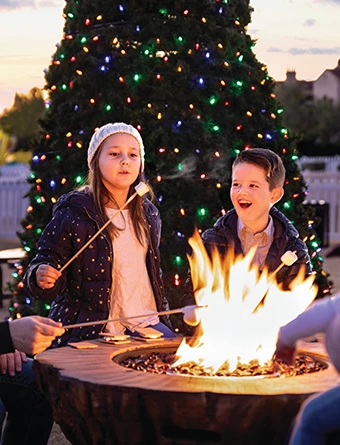 two kids making marshmallows on the firepit