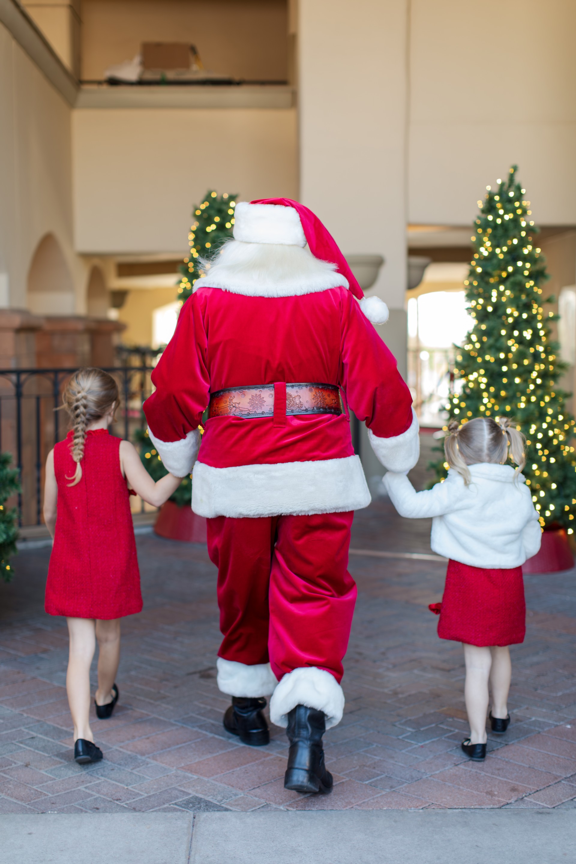 a man in a santa garment with two girls