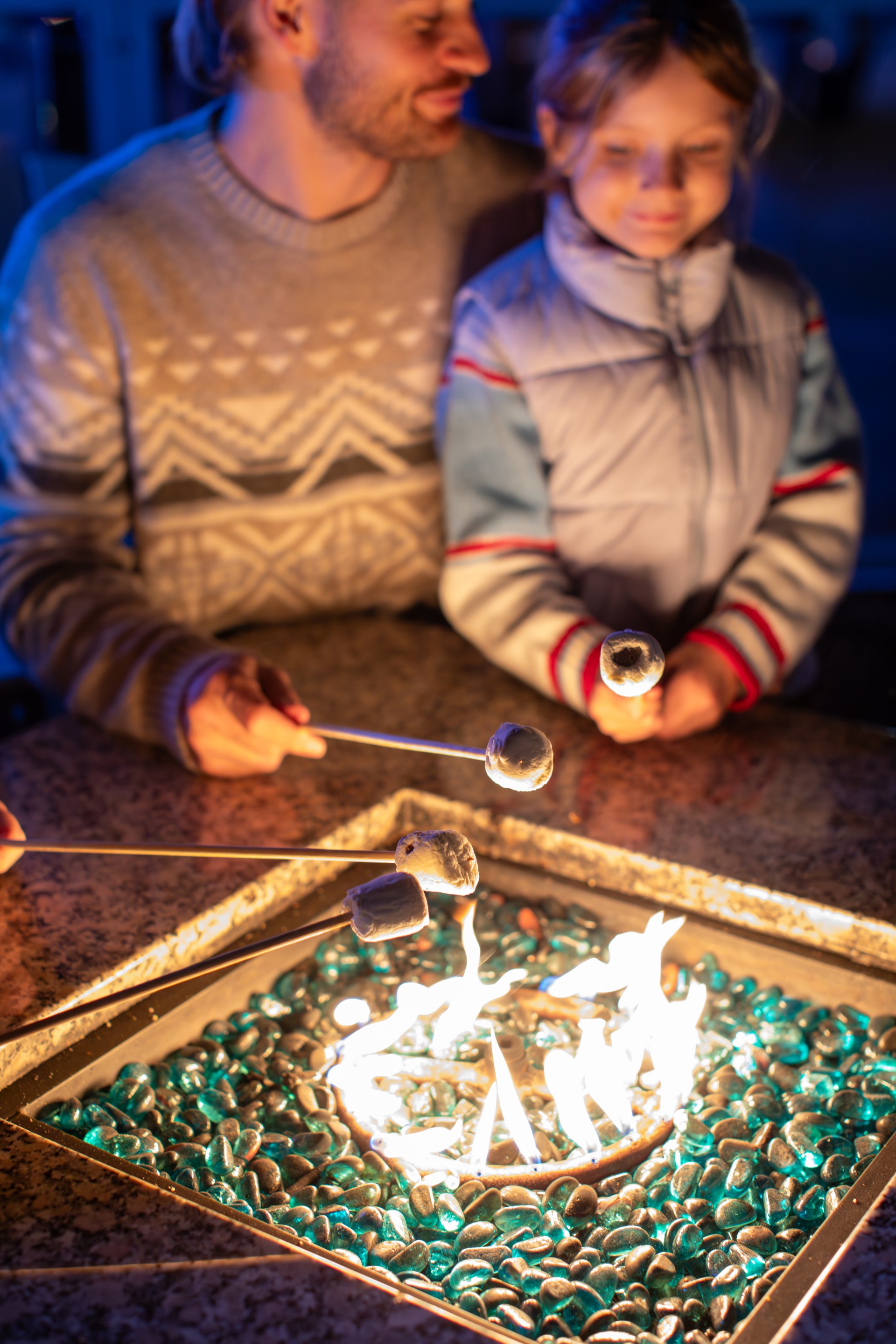 people holding sticks over a fire