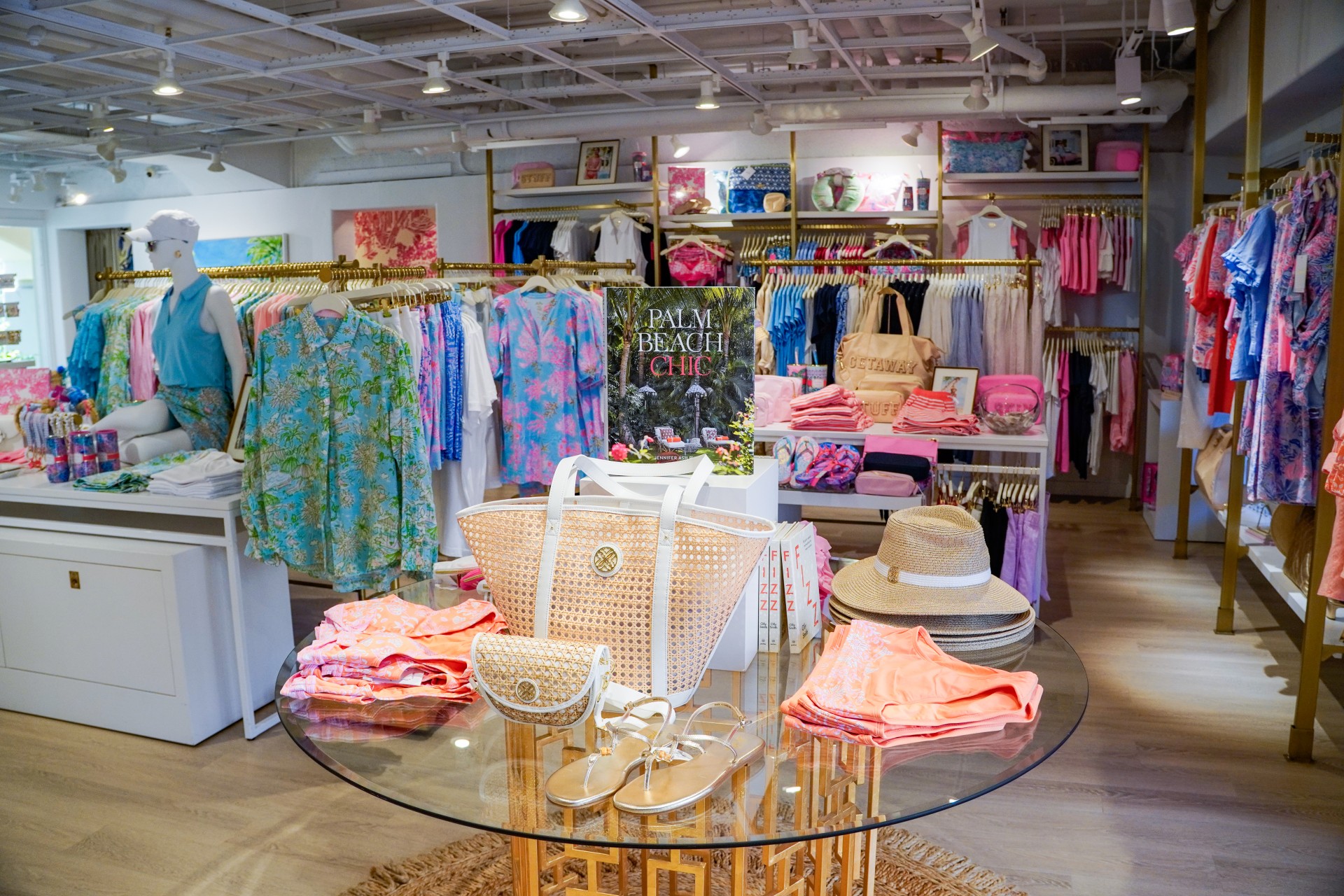 a store with a glass table with a table with clothes and a book