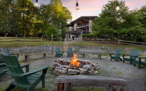 a fire pit with chairs and a building in the background main